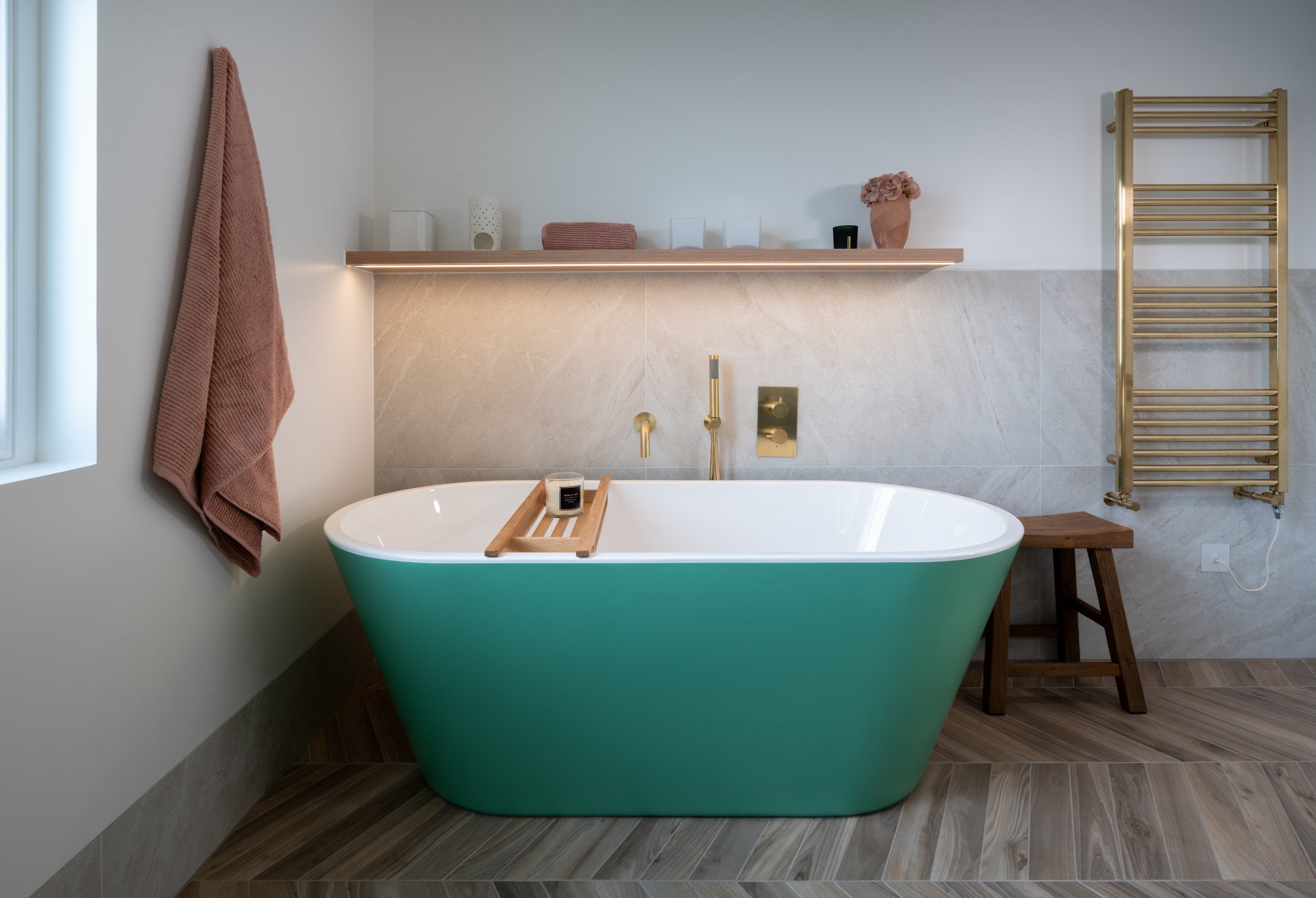 Modern zen bathroom with earthy tones and green bathtub
