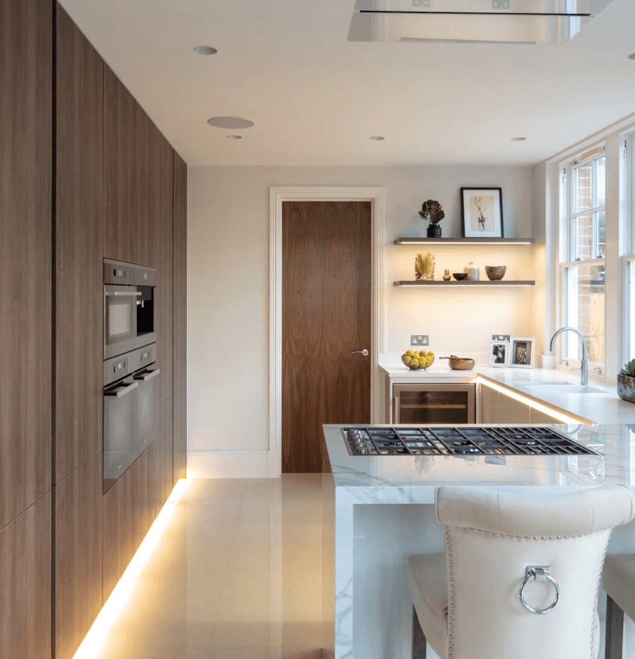 Elegant kitchen with wooden cabinets, marble countertops, and modern integrated appliances.