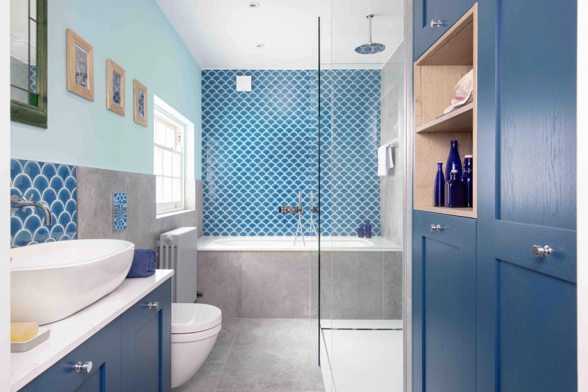 blue tiles, and bathroom cupboards to create a nautical feel, set against light grey floor tiles. 