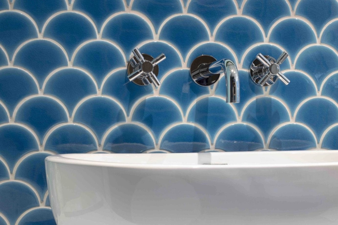 Patterned tiles for the walls alongside the royal blue bespoke cabinetry create a nautical feel.