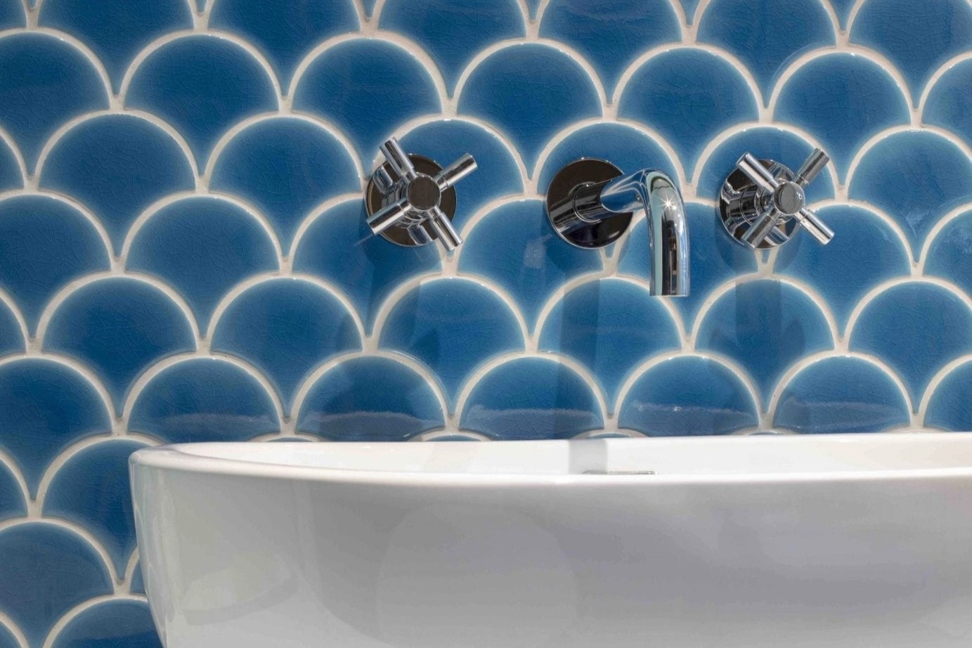 Patterned tiles for the walls alongside the royal blue bespoke cabinetry create a nautical feel.
