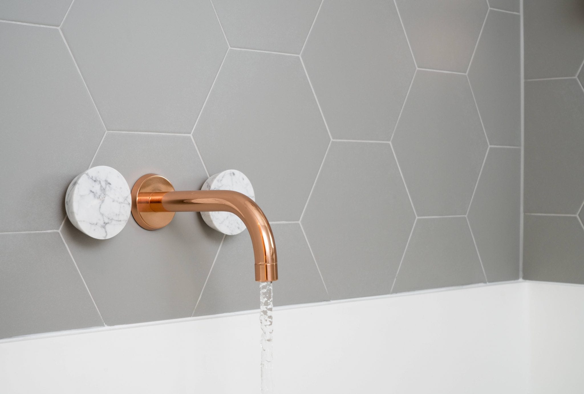 Hexagon bathroom tiles with brass tap and marble handles 